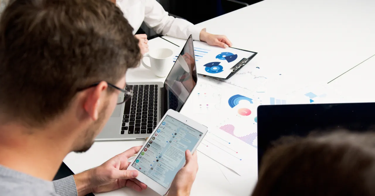A marketing team analyzing campaign performance using digital reports and charts – perfect for showcasing how Shopify merchants can track and optimize their summer strategies.