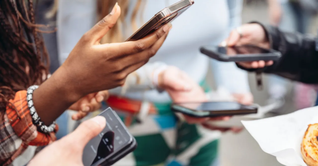 Group of people holding smartphones, engaged in social interaction or online activity.