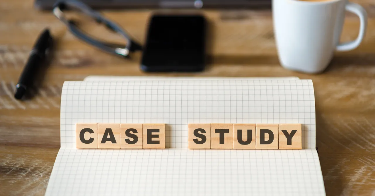 Notebook with wooden letter blocks spelling 'Case Study' on a desk with coffee, phone, and glasses.
