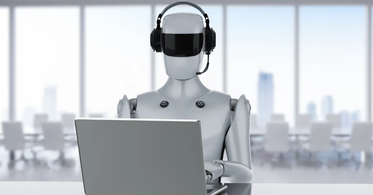 A robot with a headset sitting at a laptop, representing AI-powered customer support or virtual assistants in modern business environments.