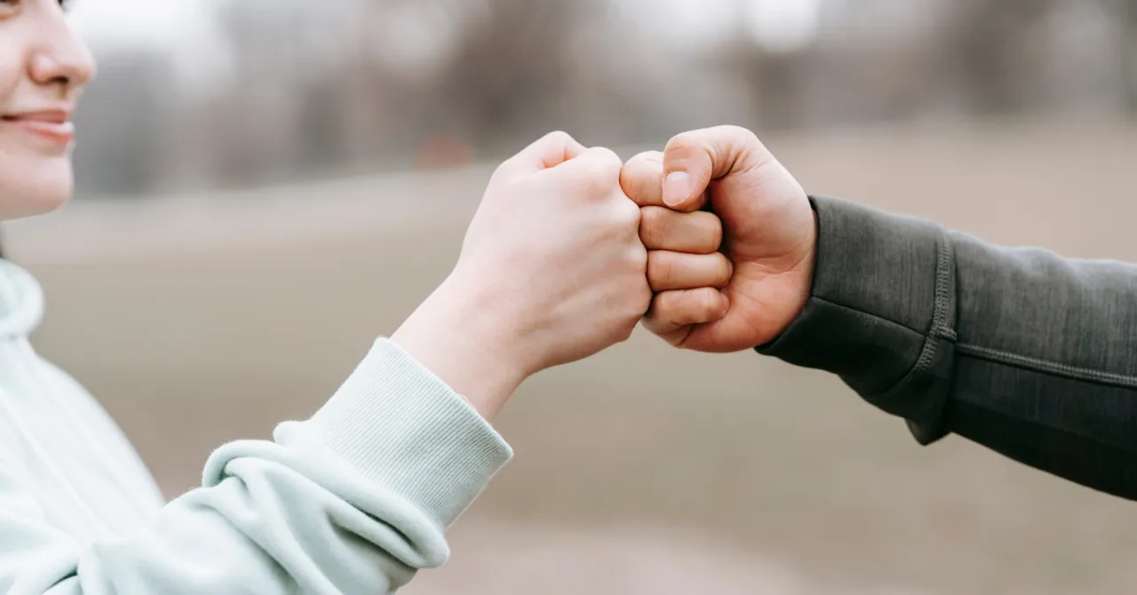 A friendly fist bump showing trust and connection—perfect for brands that deliver value, versatility, and loyalty to budget-conscious shoppers.