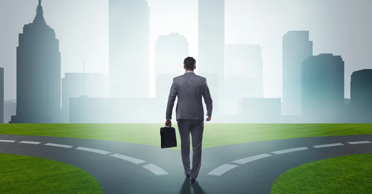 A businessman stands at a crossroads, symbolizing strategic decision-making in the face of new opportunities and challenges in the evolving digital commerce landscape.