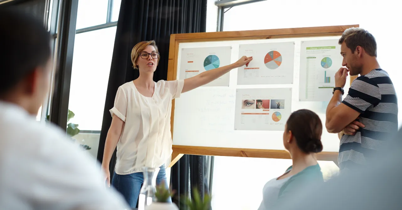 eam meeting with woman pointing at charts.