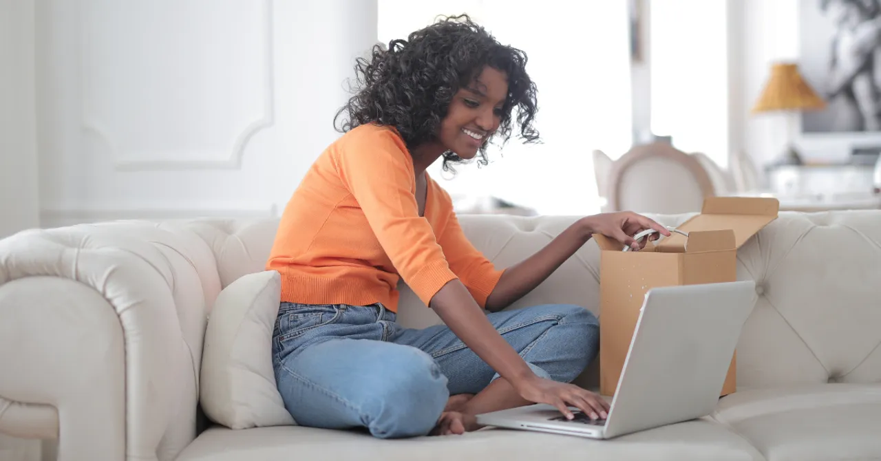 Woman unboxing product and browsing online.