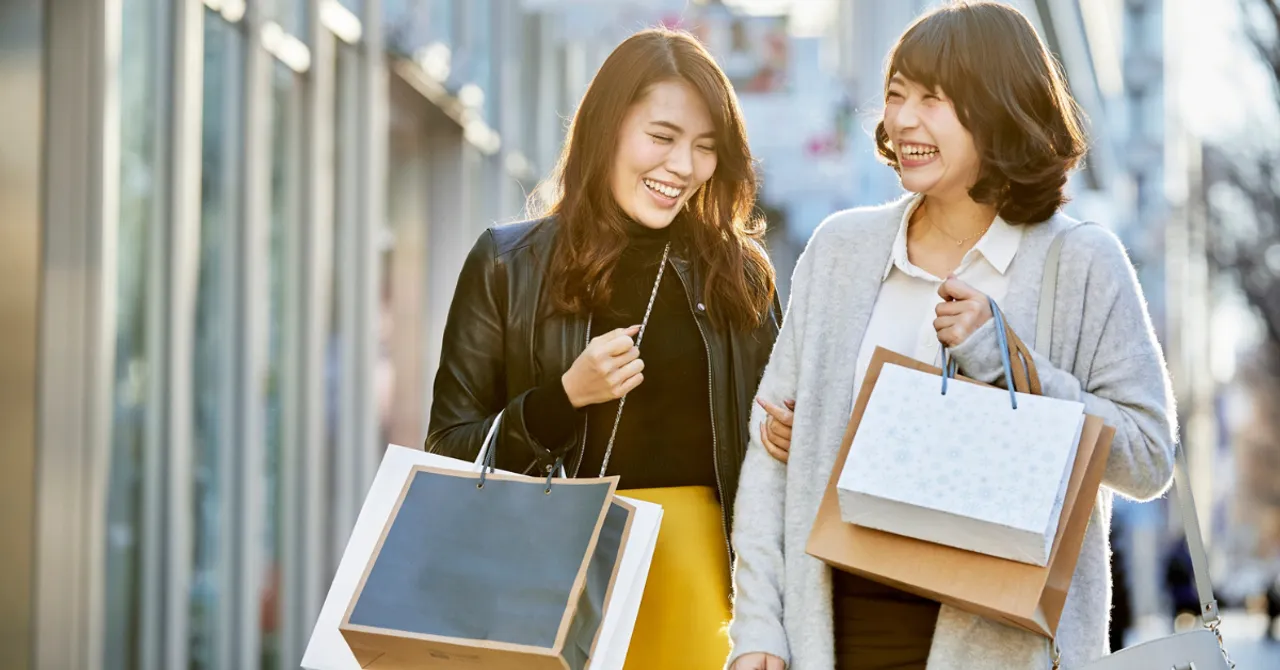 Two women happily shopping with bags.