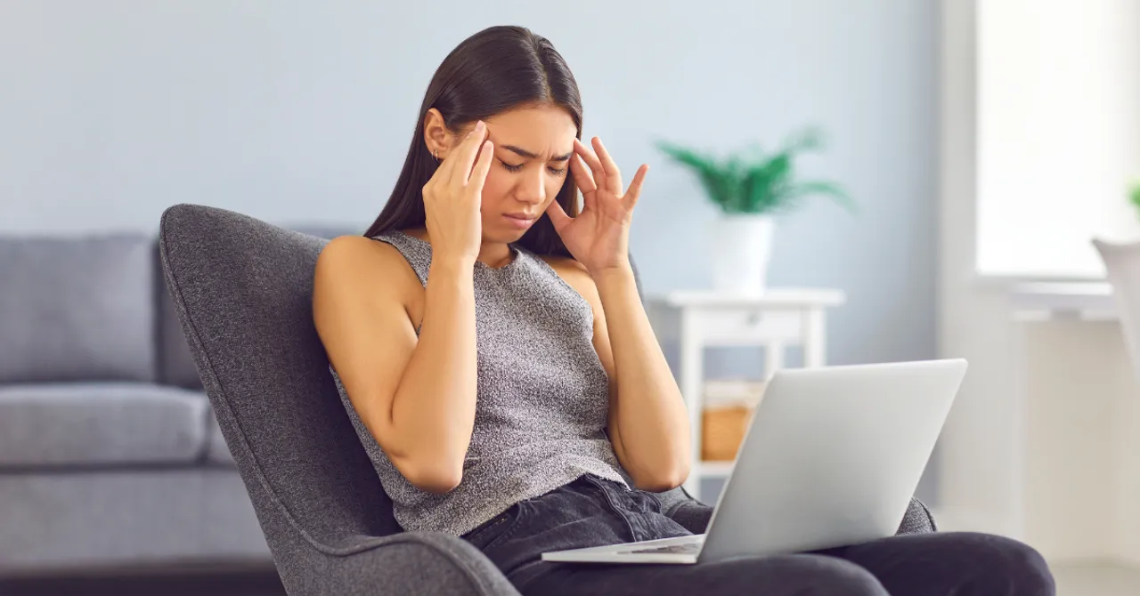 A frustrated shopper sits with her laptop, struggling to make a choice—highlighting the need for AI-powered product recommendations that bring clarity and confidence to every skincare decision.