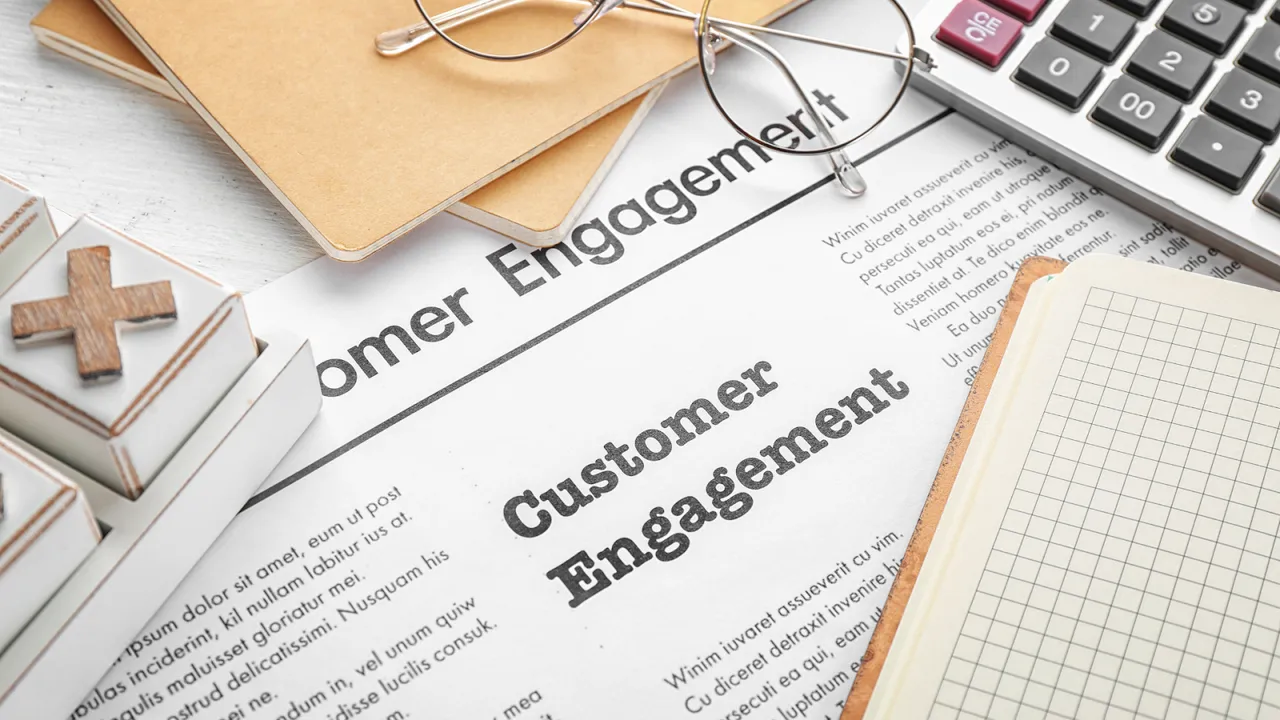 Close-up of a document titled “Customer Engagement” surrounded by office supplies, symbolizing business planning and strategies to enhance customer interaction and loyalty.