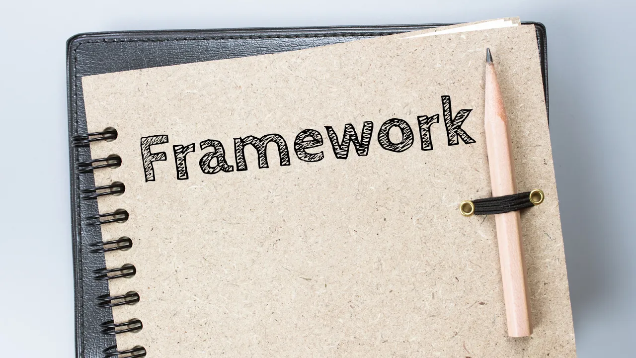 Close-up of a spiral notebook with the word "Framework" on the cover and a pencil attached, symbolizing structured planning or strategic frameworks
